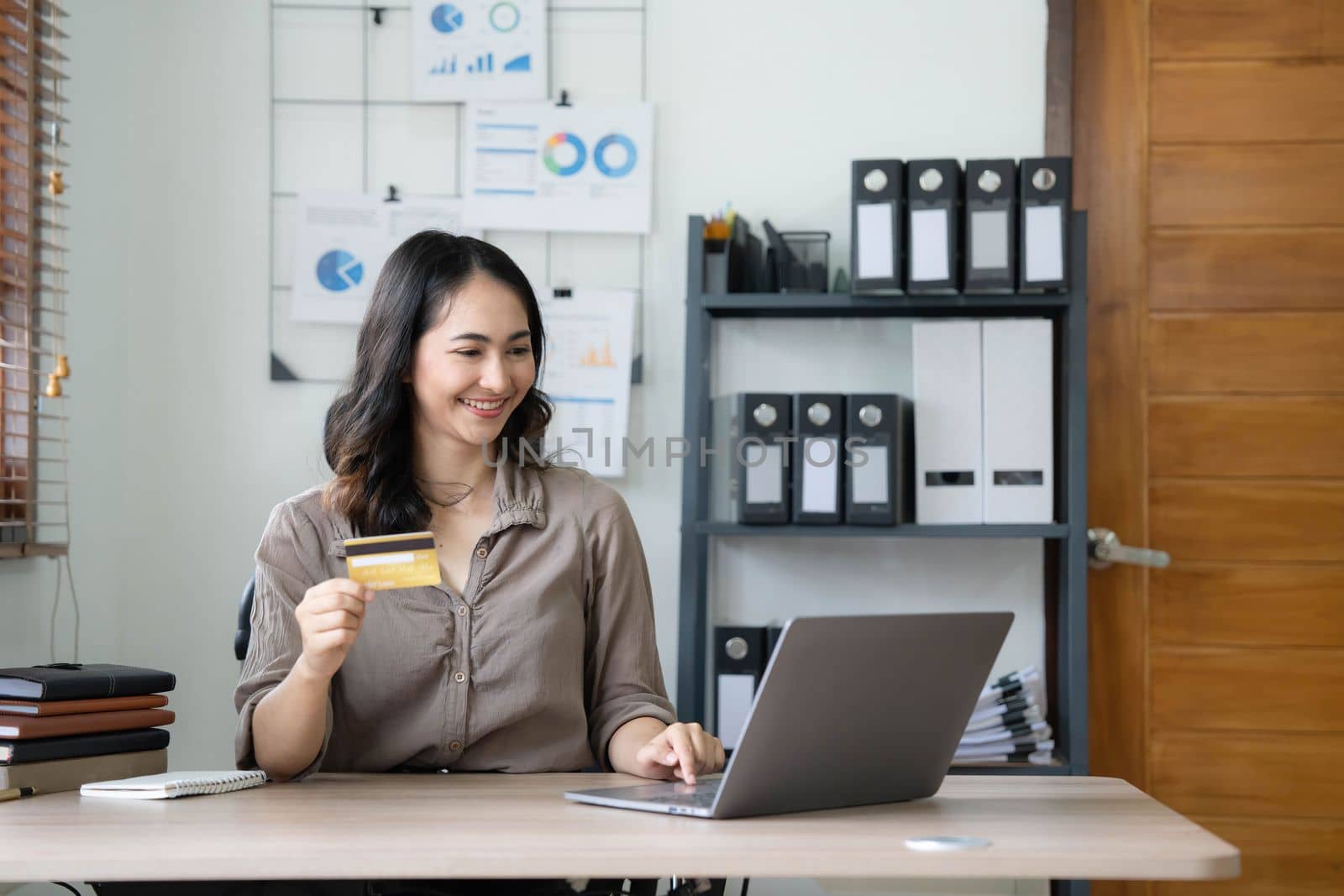 Young Asian businesswoman enjoy shopping online using credit card at home.