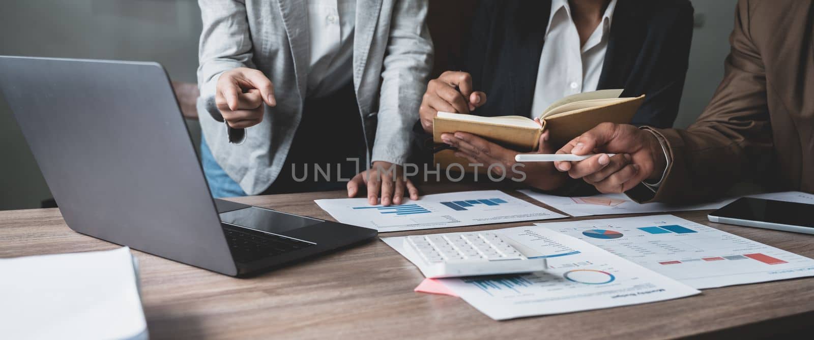 Financial analyst analysis business financial report on laptop during discussion at meeting of corporate showing the results of their successful teamwork, business meeting concept, Marketing.