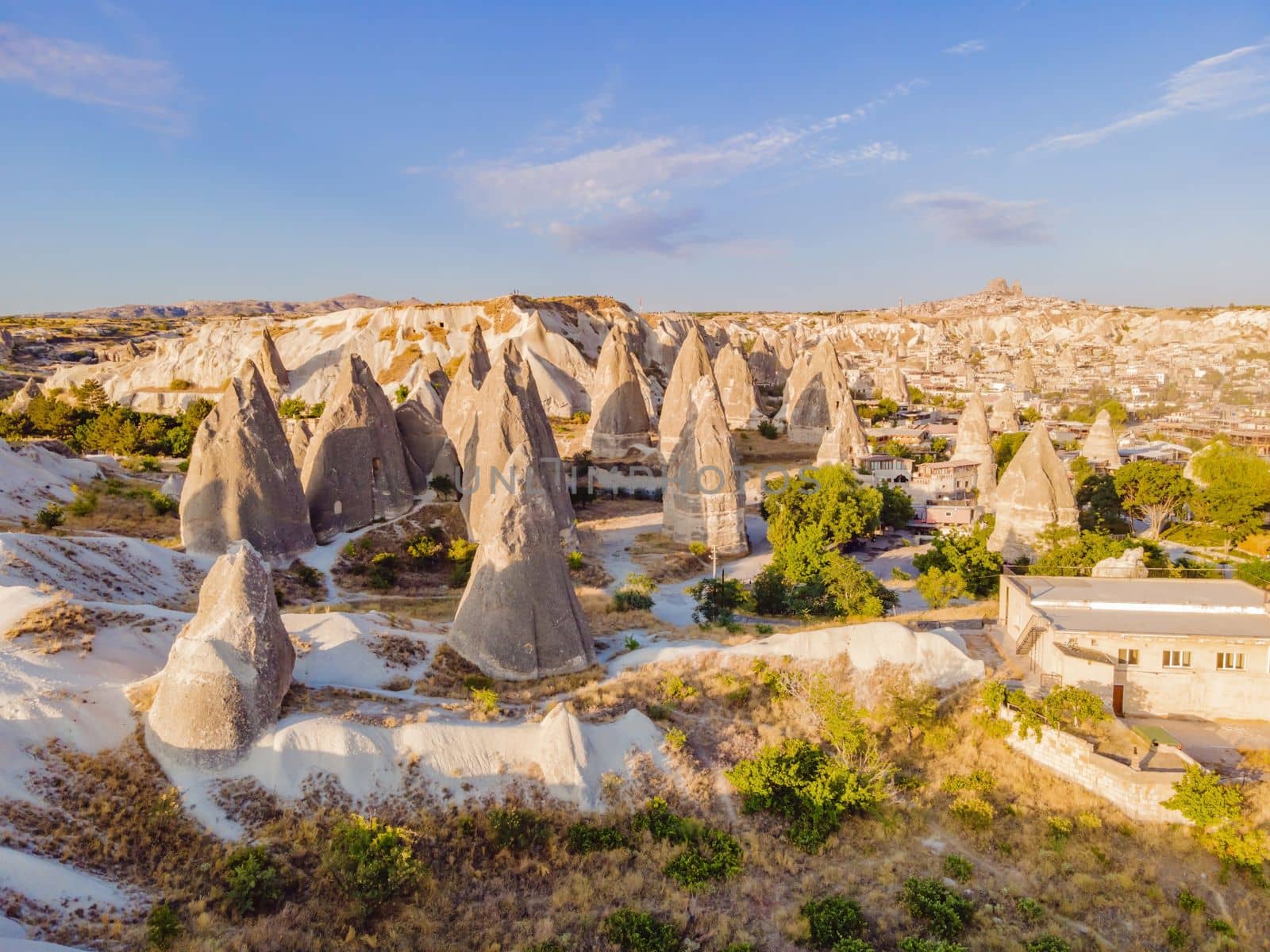 Colorful hot air balloons flying over at fairy chimneys valley in Nevsehir, Goreme, Cappadocia Turkey. Spectacular panoramic drone view of the underground city and ballooning tourism. High quality by galitskaya