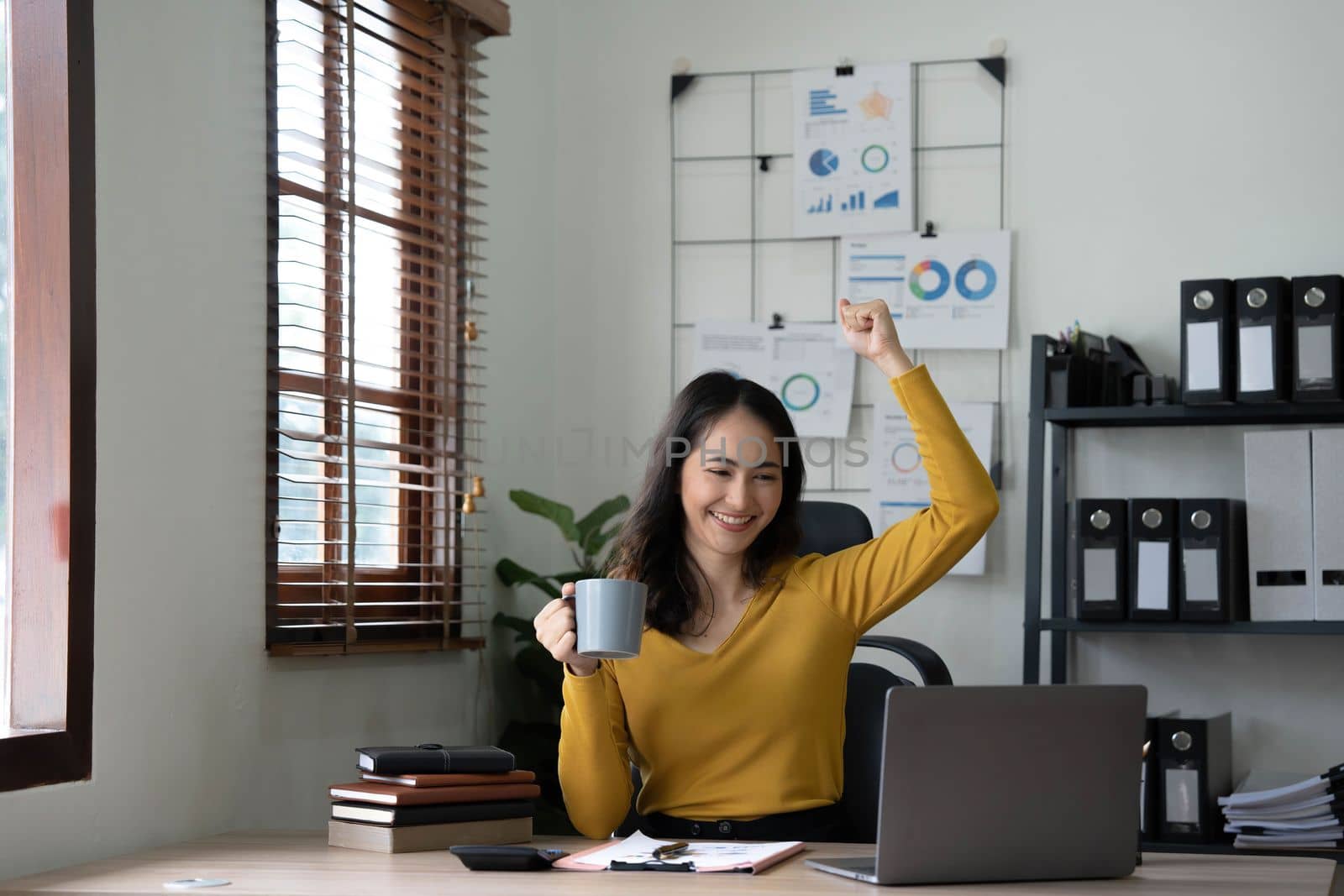 Pretty Asian businesswoman sitting on a laptop And the work came out successfully and the goal was achieved, happy and satisfied with her..