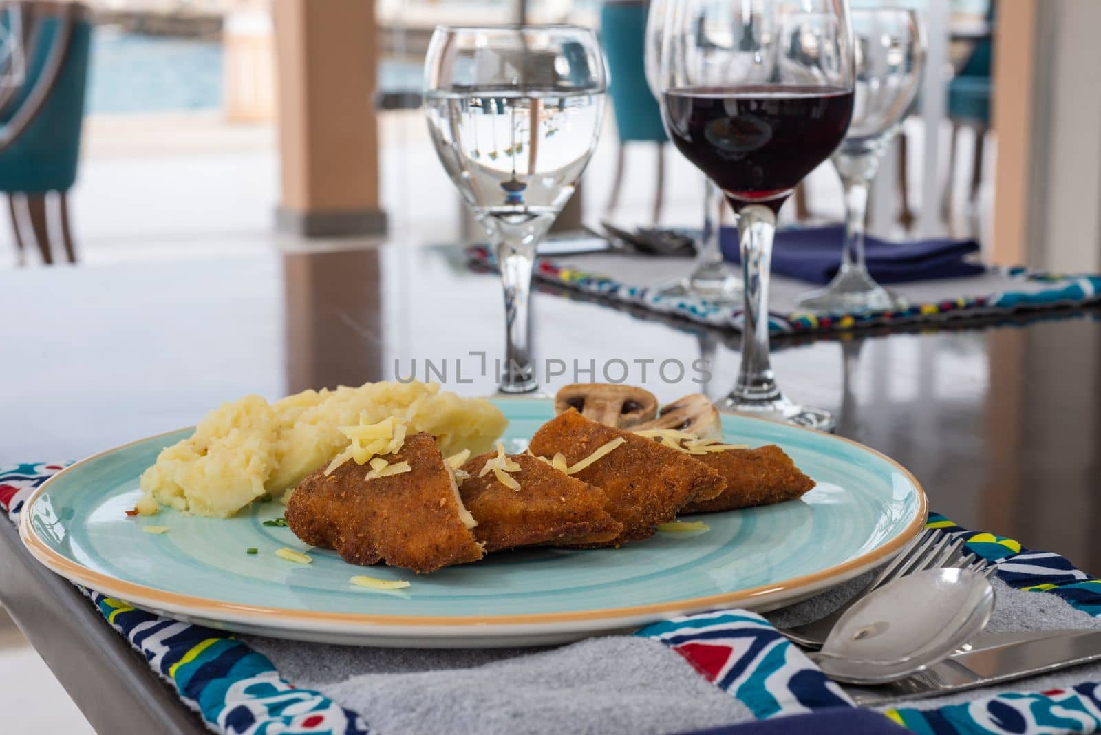 Stuffed chicken panne a la carte meal with mushrooms and mashed potato at restaurant table setting