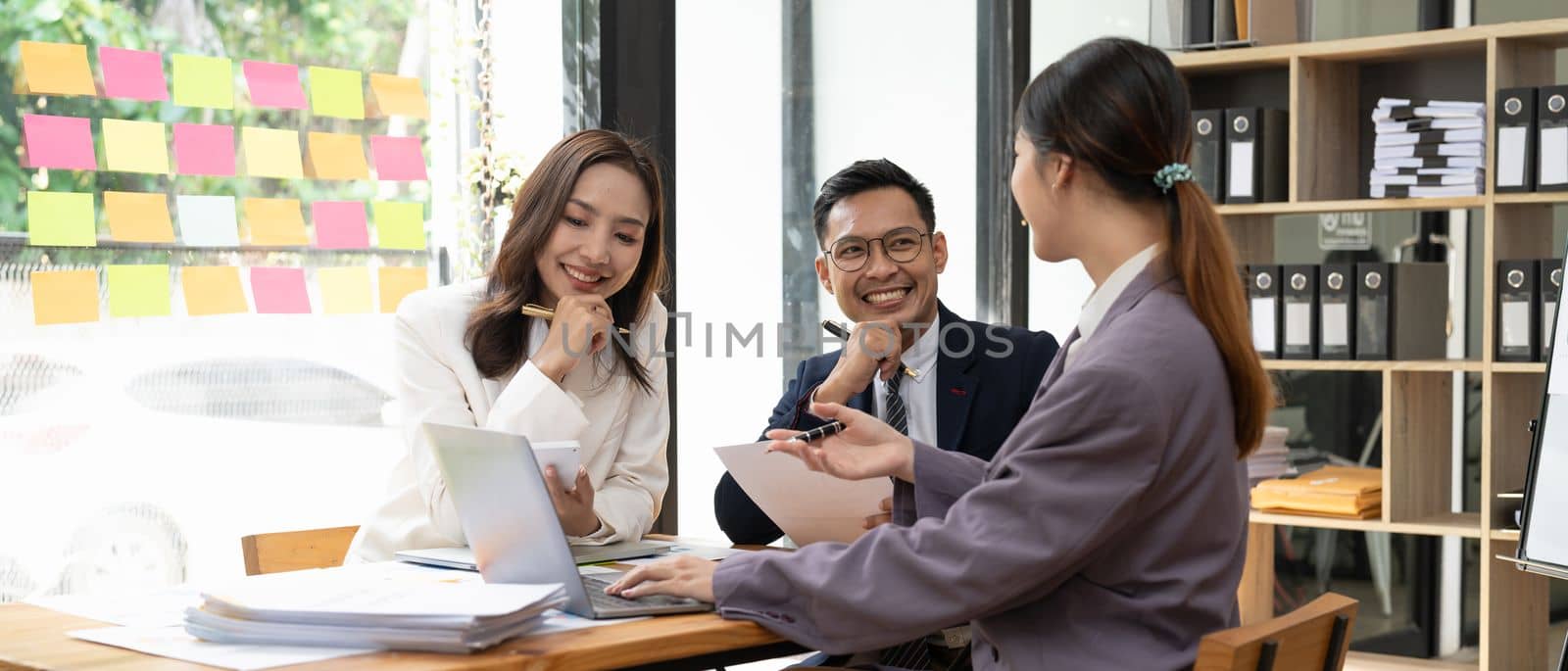Asian business advisers brainstorms a meeting to analyze and discuss the situation on the financial report in the workspace, Investment Consultant, Financial advisor accounting concept.