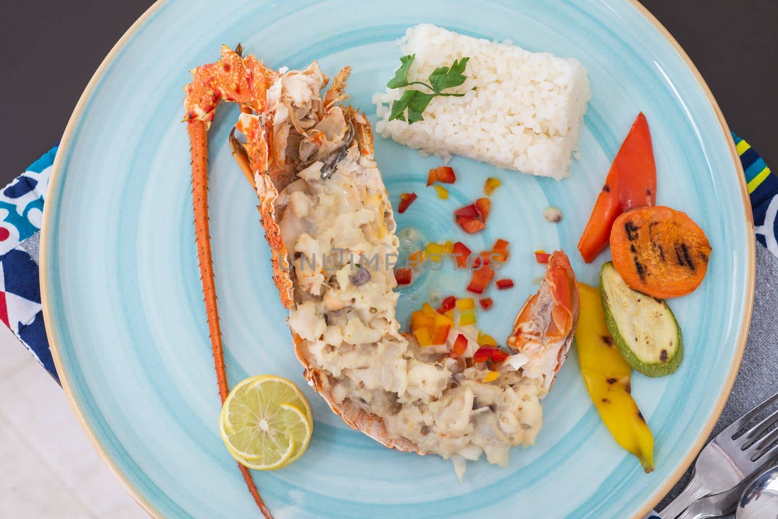 Stuffed lobster dish a la carte meal with white rice and vegetables at restaurant table setting