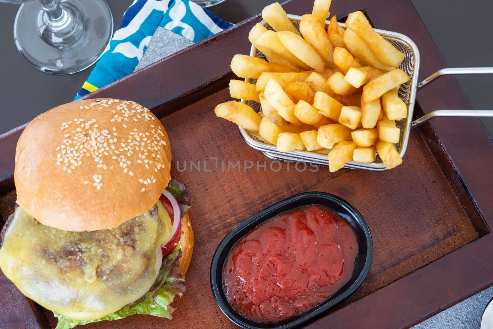 Cheeseburger a la carte meal with tomato sauce on wooden plate by paulvinten