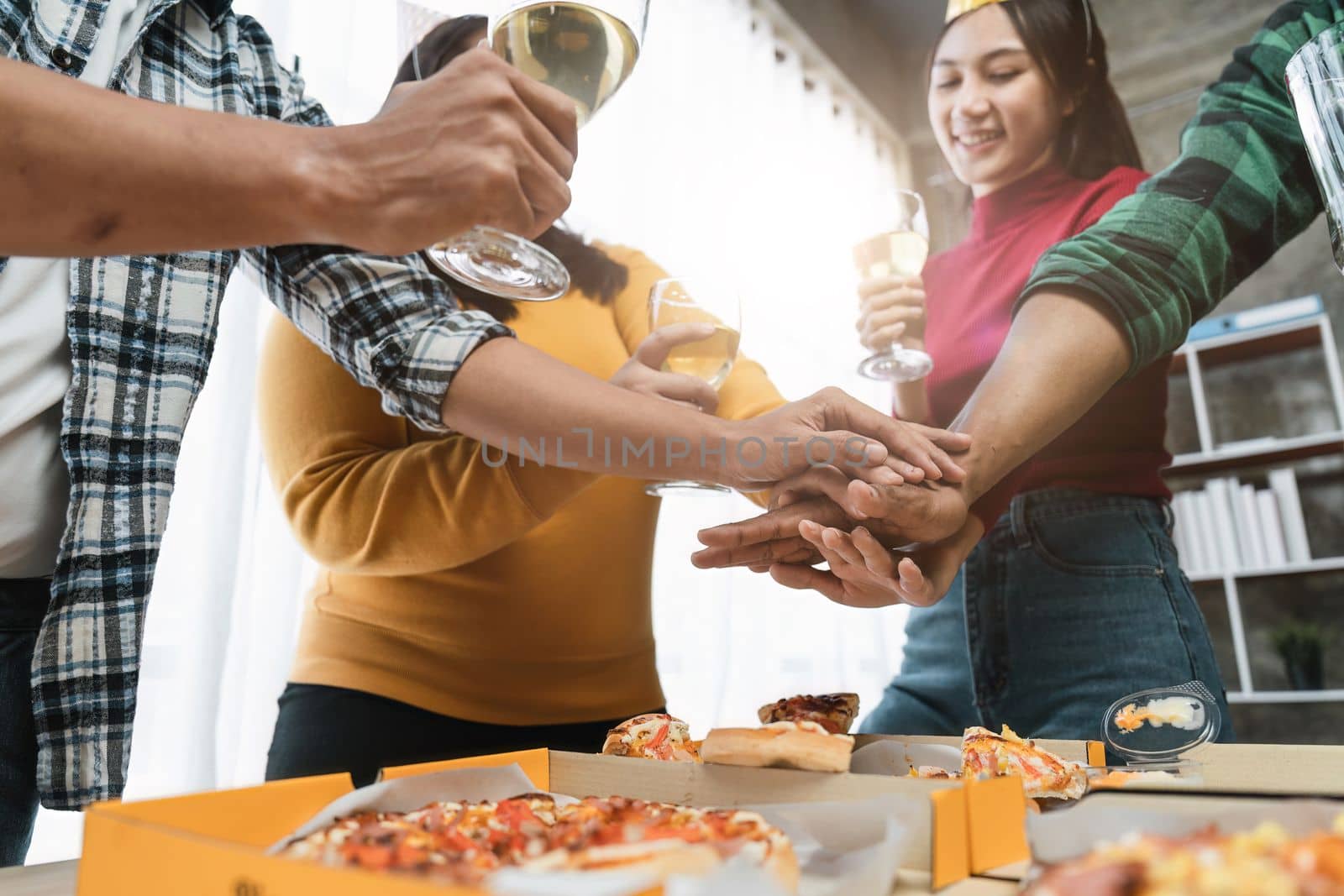 Group of happy colleagues having fun at a new year celebration or business success. Coworkers with diverse people at the office party.