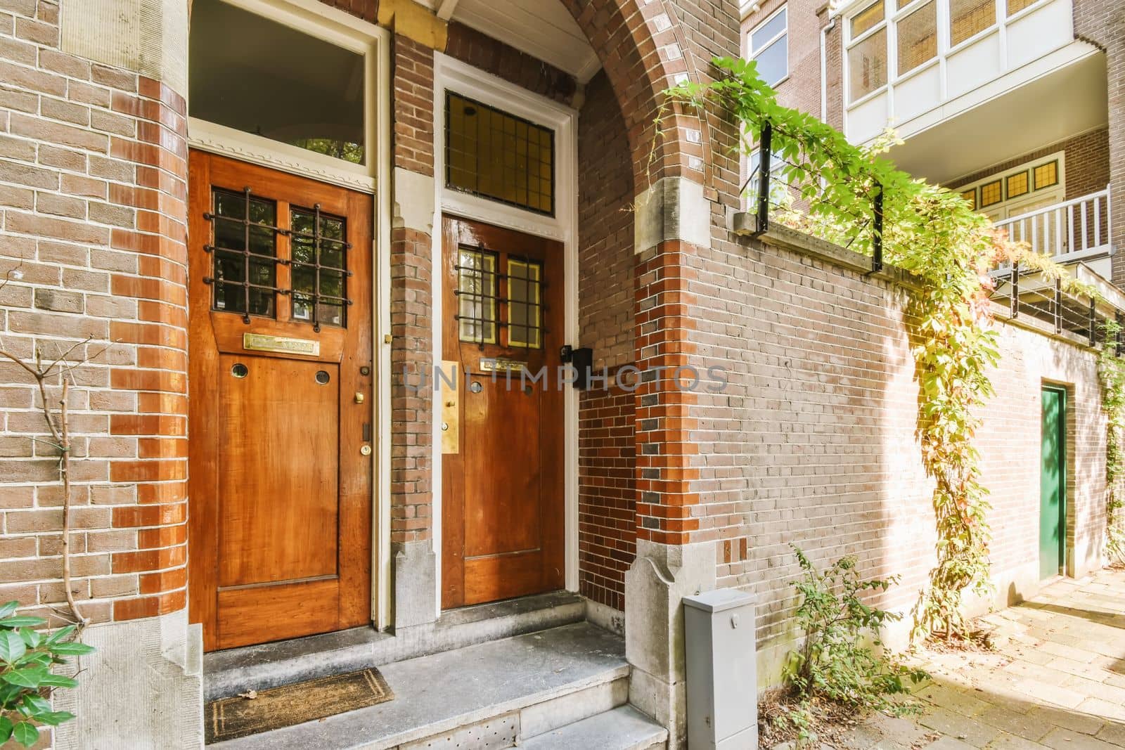 two wooden doors on a brick house by casamedia