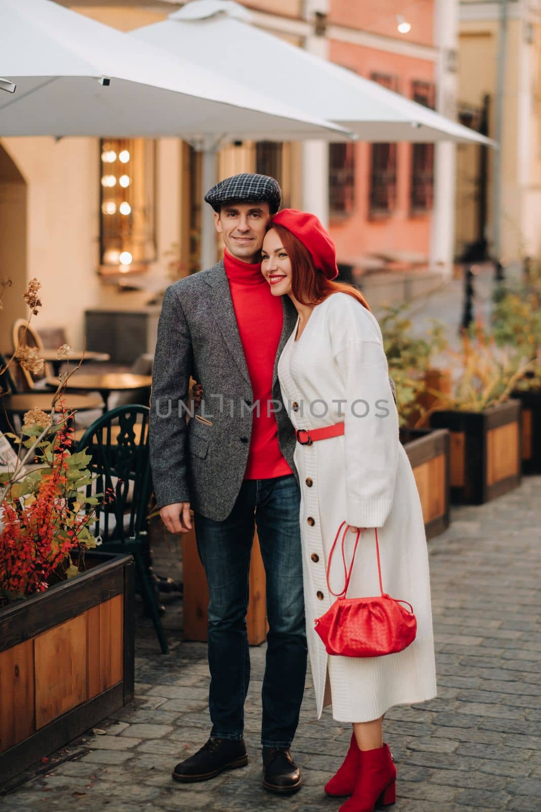 Portrait of a happy couple walking on the street in an autumn city. Stylish couple in retro style in autumn in the city.