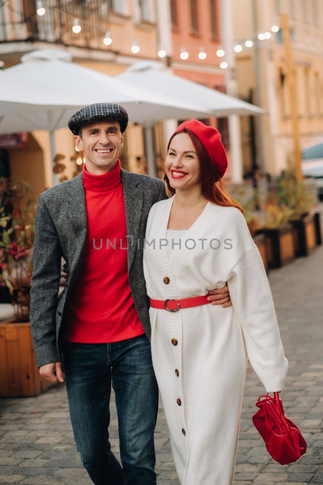 Portrait of a happy couple walking on the street in an autumn city. Stylish couple in retro style in autumn in the city.