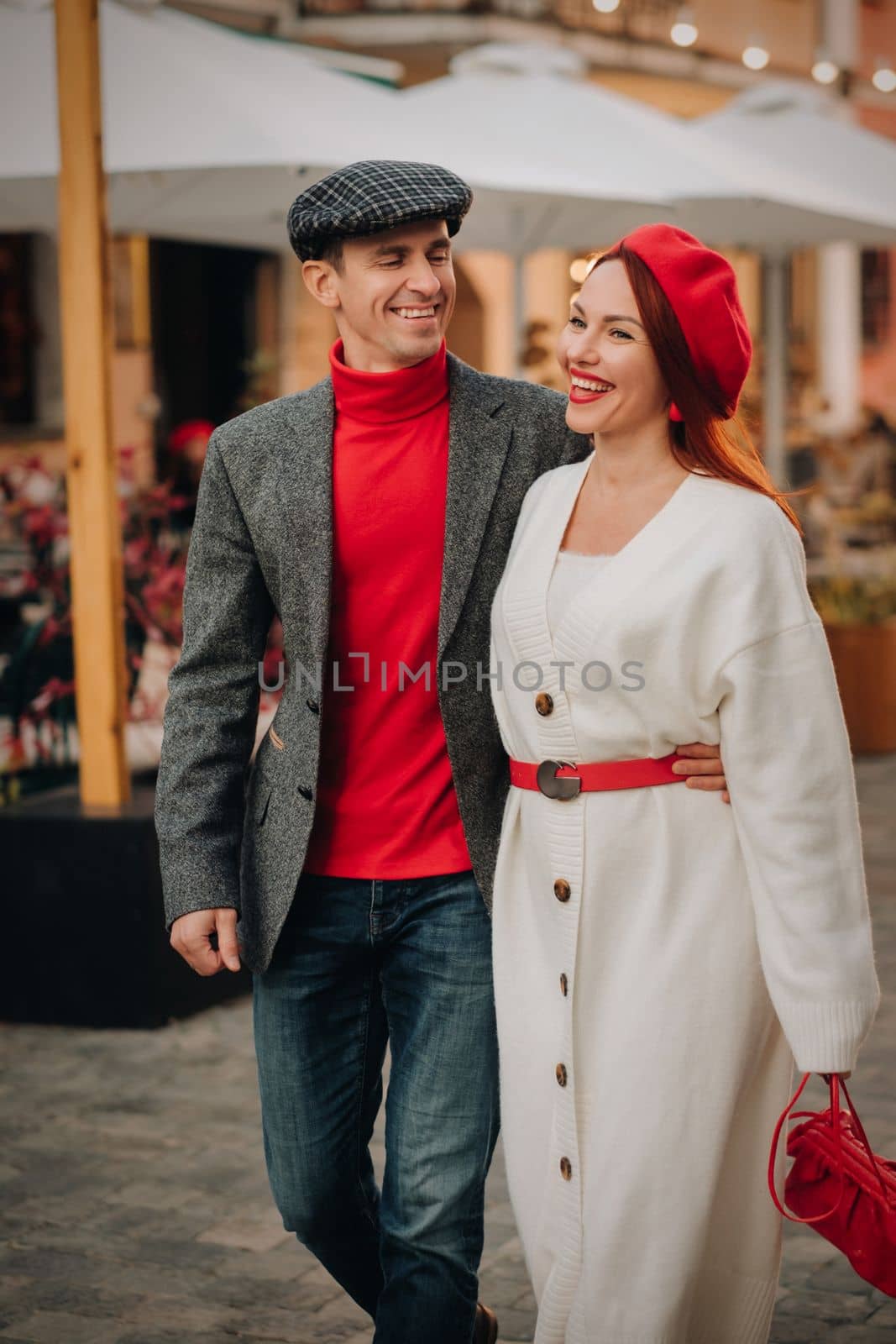 Portrait of a happy couple walking on the street in an autumn city. Stylish couple in retro style in autumn in the city.