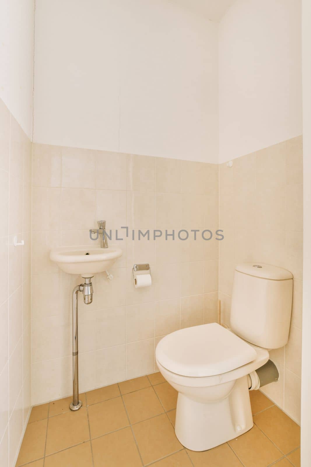 a bathroom with tile flooring and white wall tiles on the walls, toilet is in the center of the room