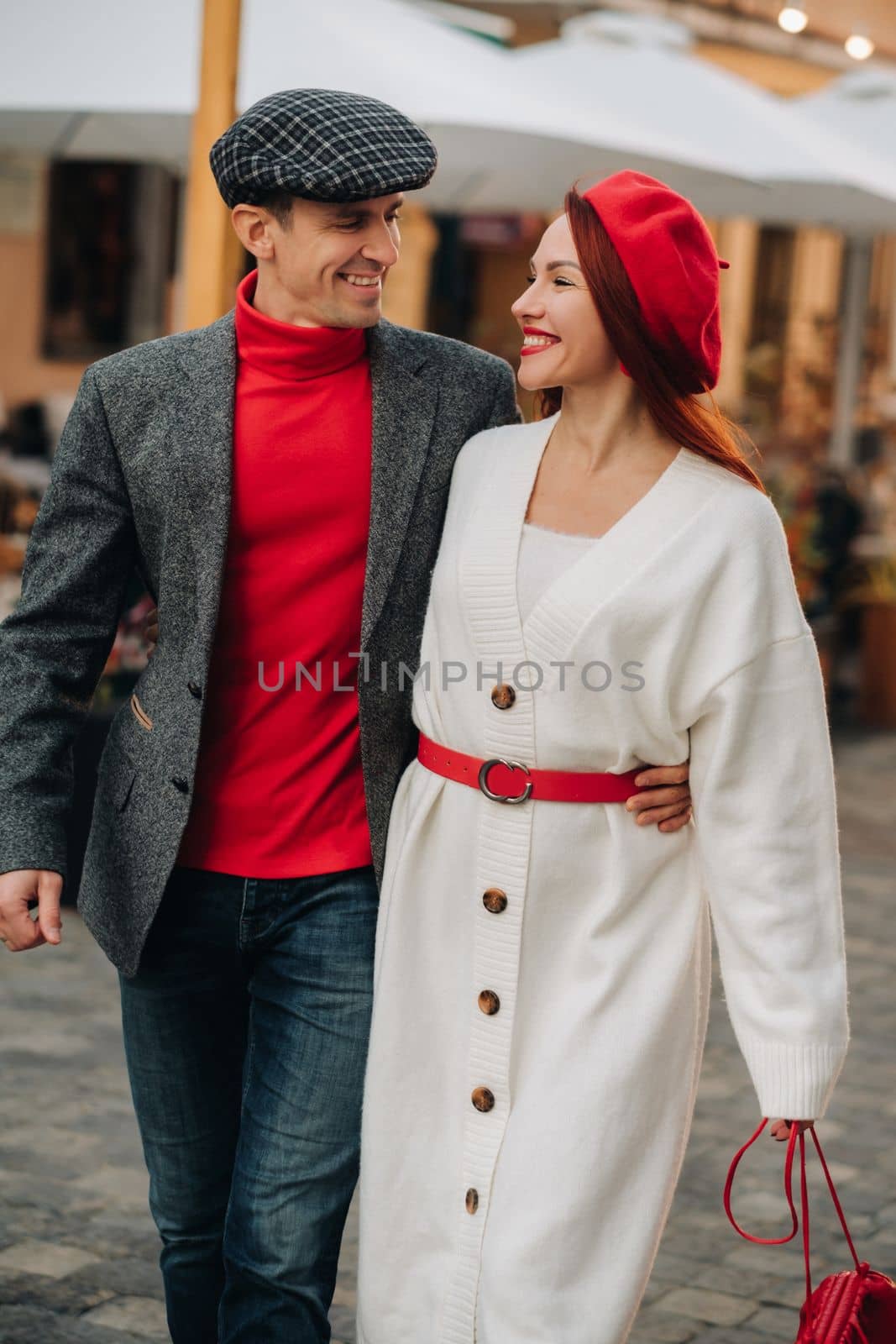 Portrait of a happy couple walking on the street in an autumn city. Stylish couple in retro style in autumn in the city.