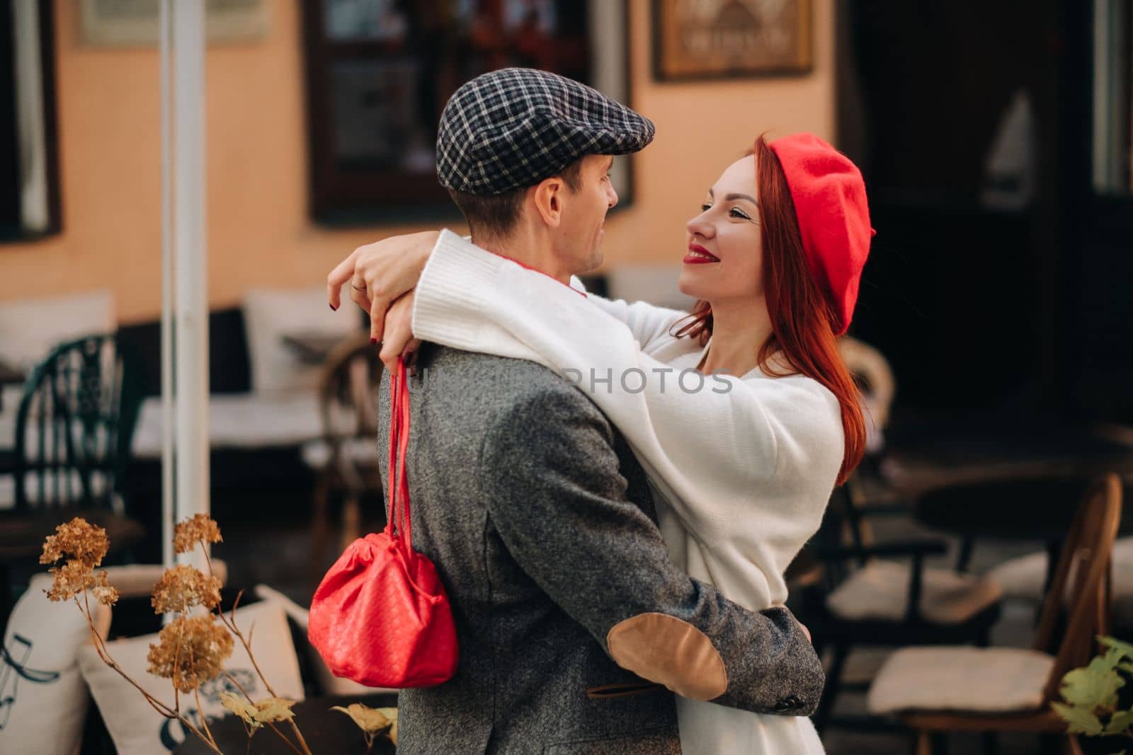 Portrait of a happy couple hugging on the street in an autumn city. Retro stylish couple in autumn in the city by Lobachad