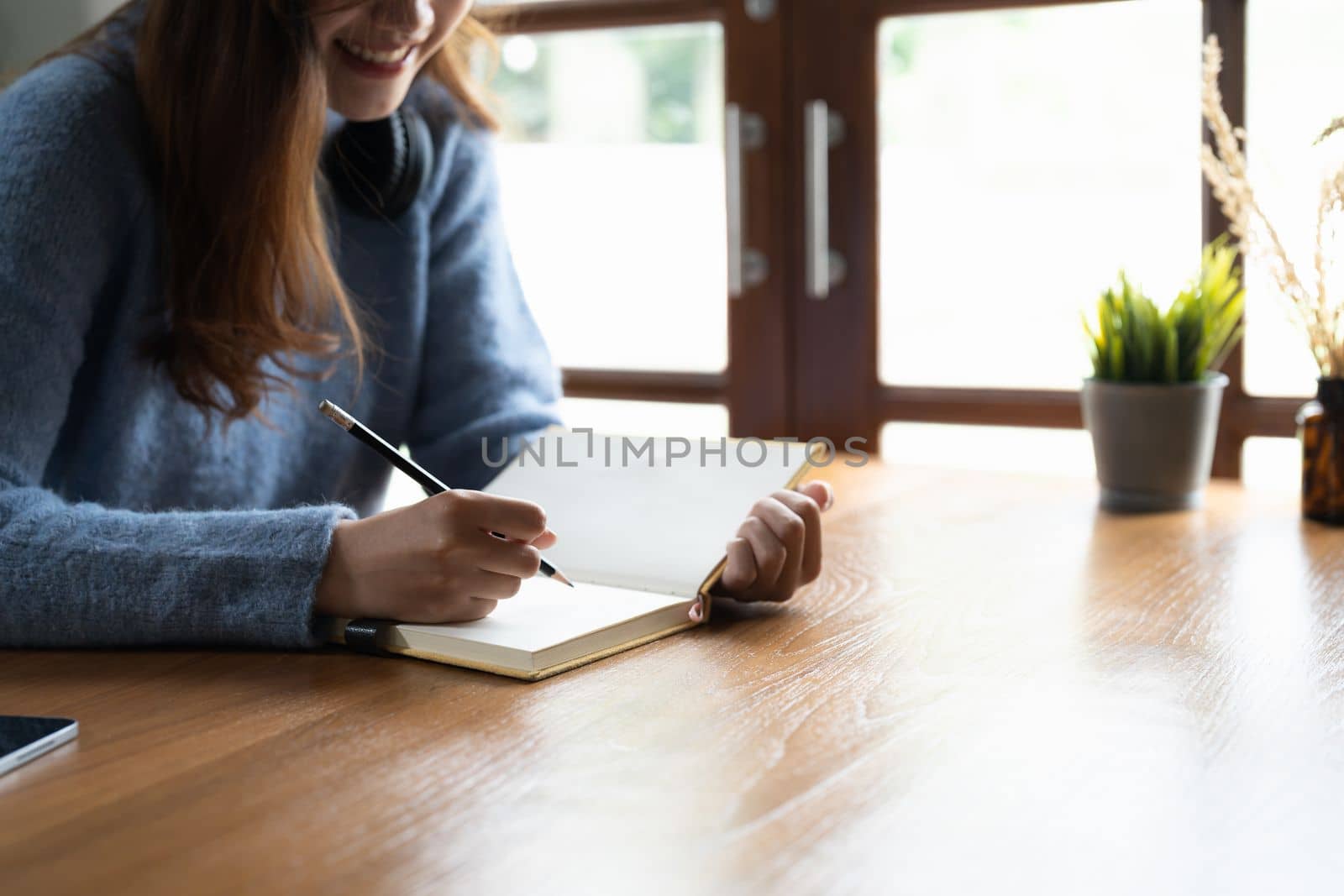 Close up of woman study online distant on laptop make note write in notebook sitting on desk at home. Smart female writer or student handwrite in stationery notepad, planning or making list