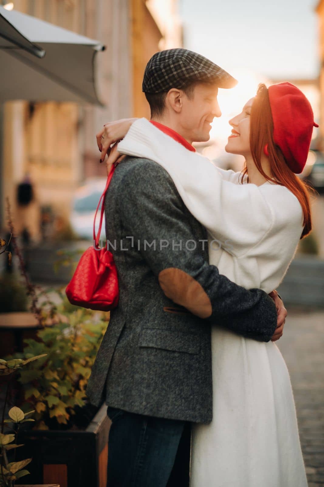 Portrait of a happy couple hugging on the street in an autumn city. Retro stylish couple in autumn in the city by Lobachad