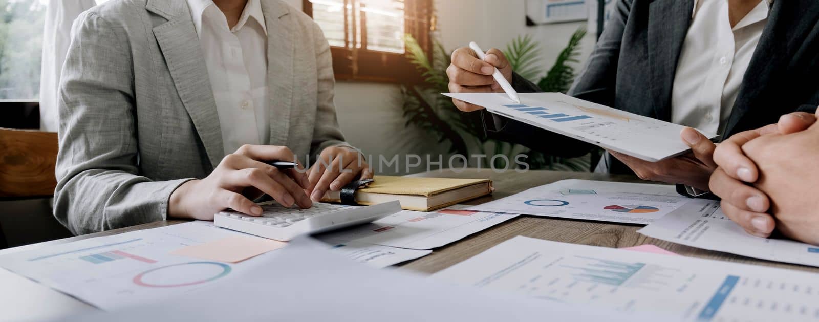 Business People Meeting using laptop computer,calculator,notebook,stock market chart paper for analysis Plans to improve quality next month. Conference Discussion Corporate Concept.