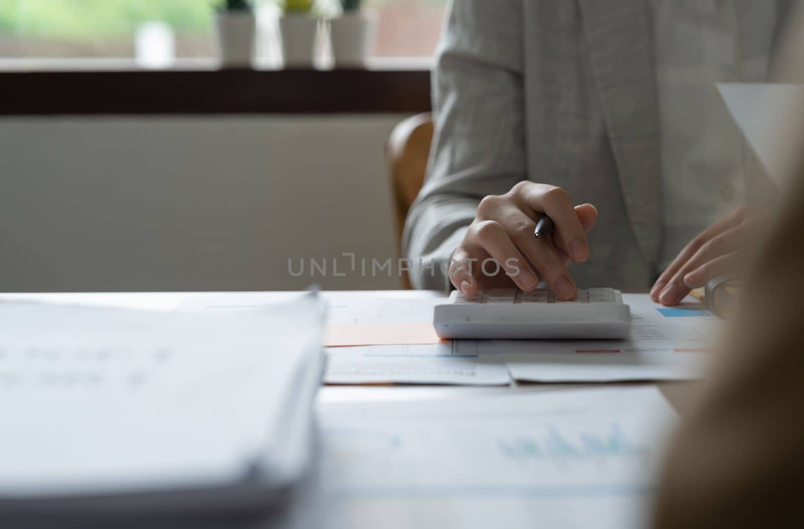 Close up woman using calculator financial documents, managing planning budget, accounting expenses.