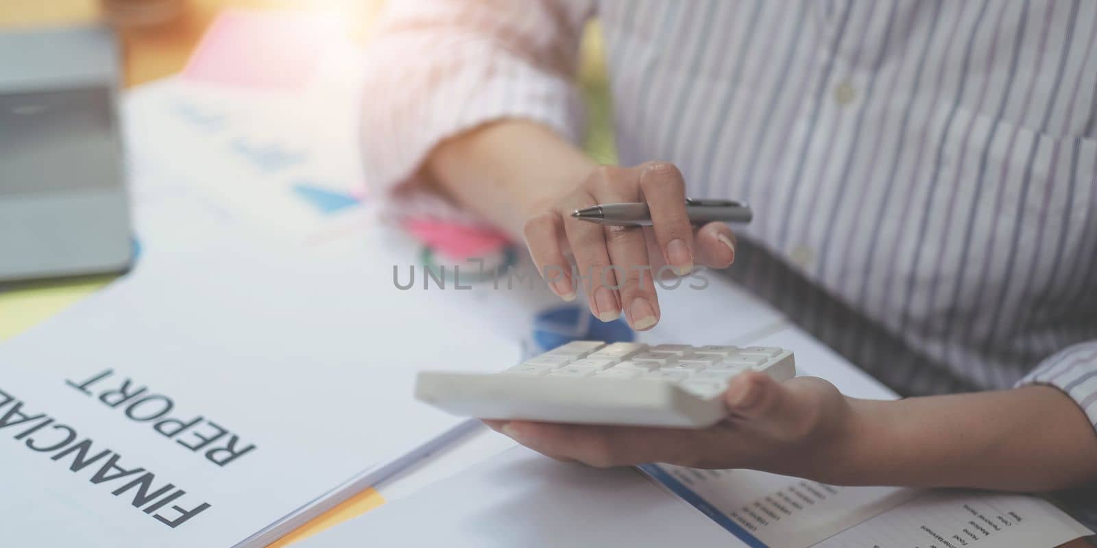 Close up Business woman using calculator and laptop for do math finance on wooden desk in office and business working background, tax, accounting, statistics and analytic research concept.