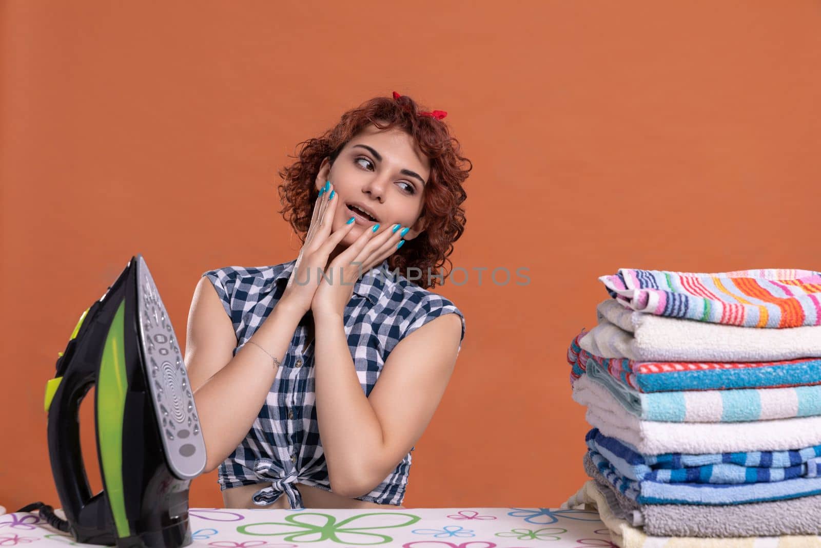 A surprised look on his face. Hands placed on cheeks. An attractive girl with curly hair. A plaid shirt tied in a knot.