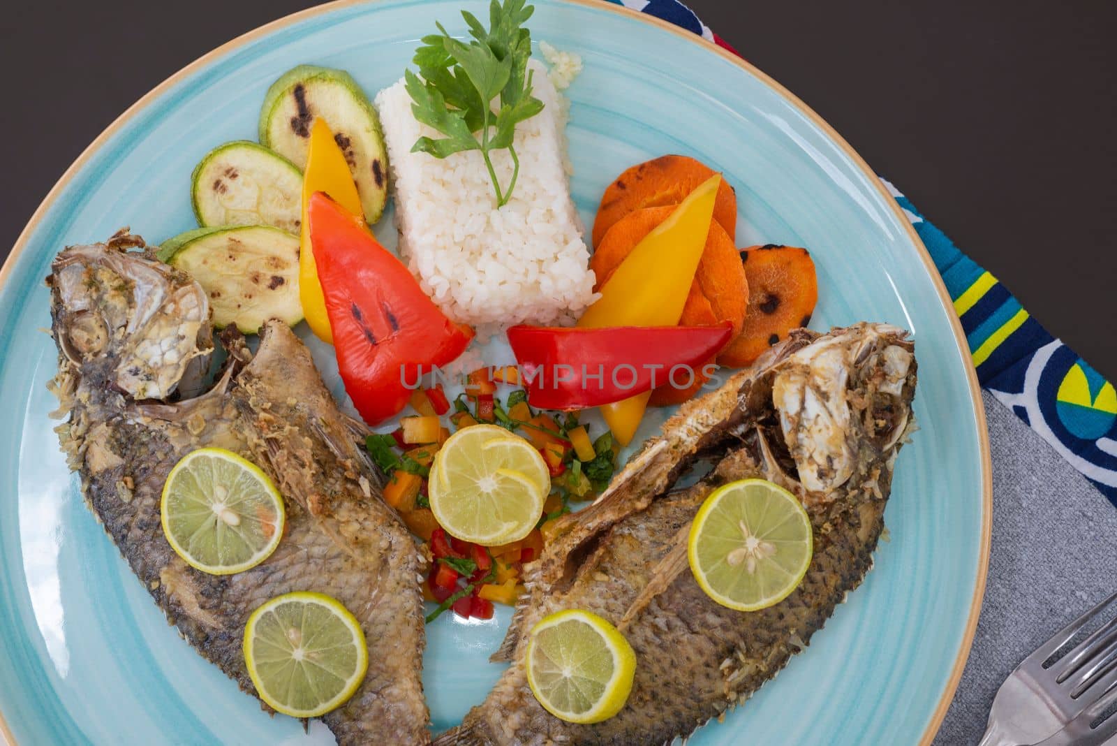 Grilled fish a la carte meal with white steamed rice on plate at restaurant table setting