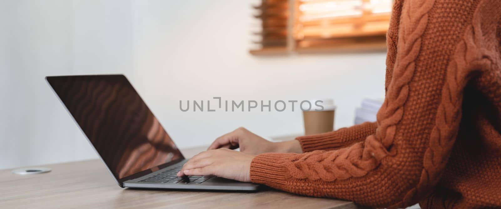 Close up of woman hands typing on laptop computer keyboard on table at home by nateemee