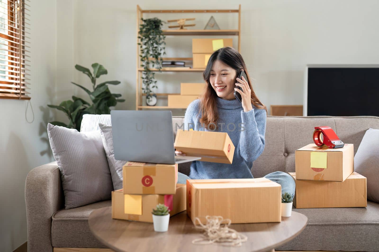 Small business entrepreneur SME freelance woman using phone call receive from customer checking product on stock at home office, online marketing packaging delivery box, SME e-commerce concept.
