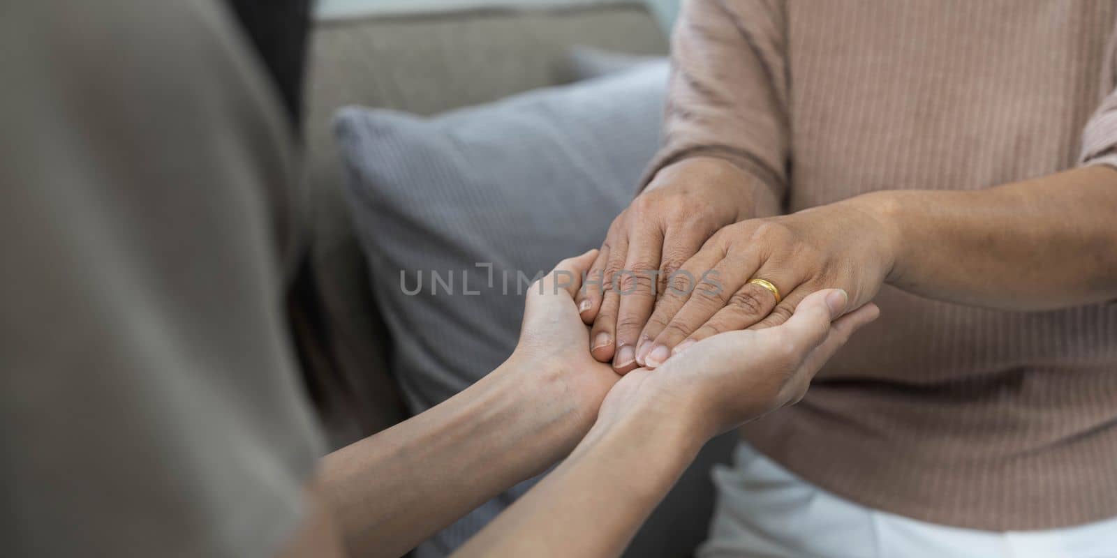 people, age, family, care and support concept - close up of senior and young woman holding hands by wichayada