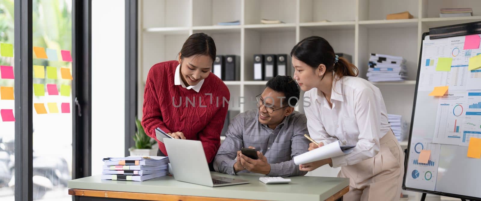 Diverse international executive business people working on project at boardroom meeting table using laptop computers. Multiracial team discussing project strategy working together in modern office