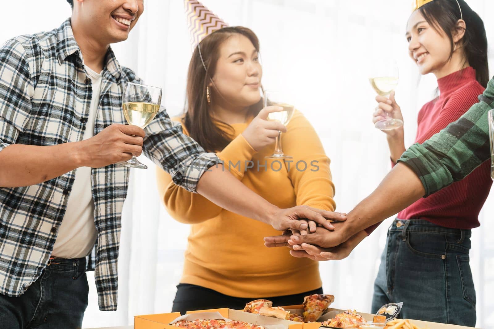 Group of happy colleagues having fun at a new year celebration or business success. Coworkers with diverse people at the office party by nateemee