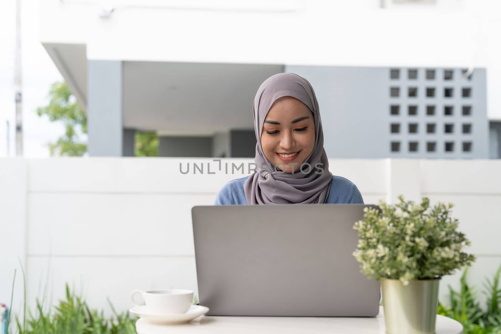 Portrait of Muslim asian woman in hijab using laptop at home