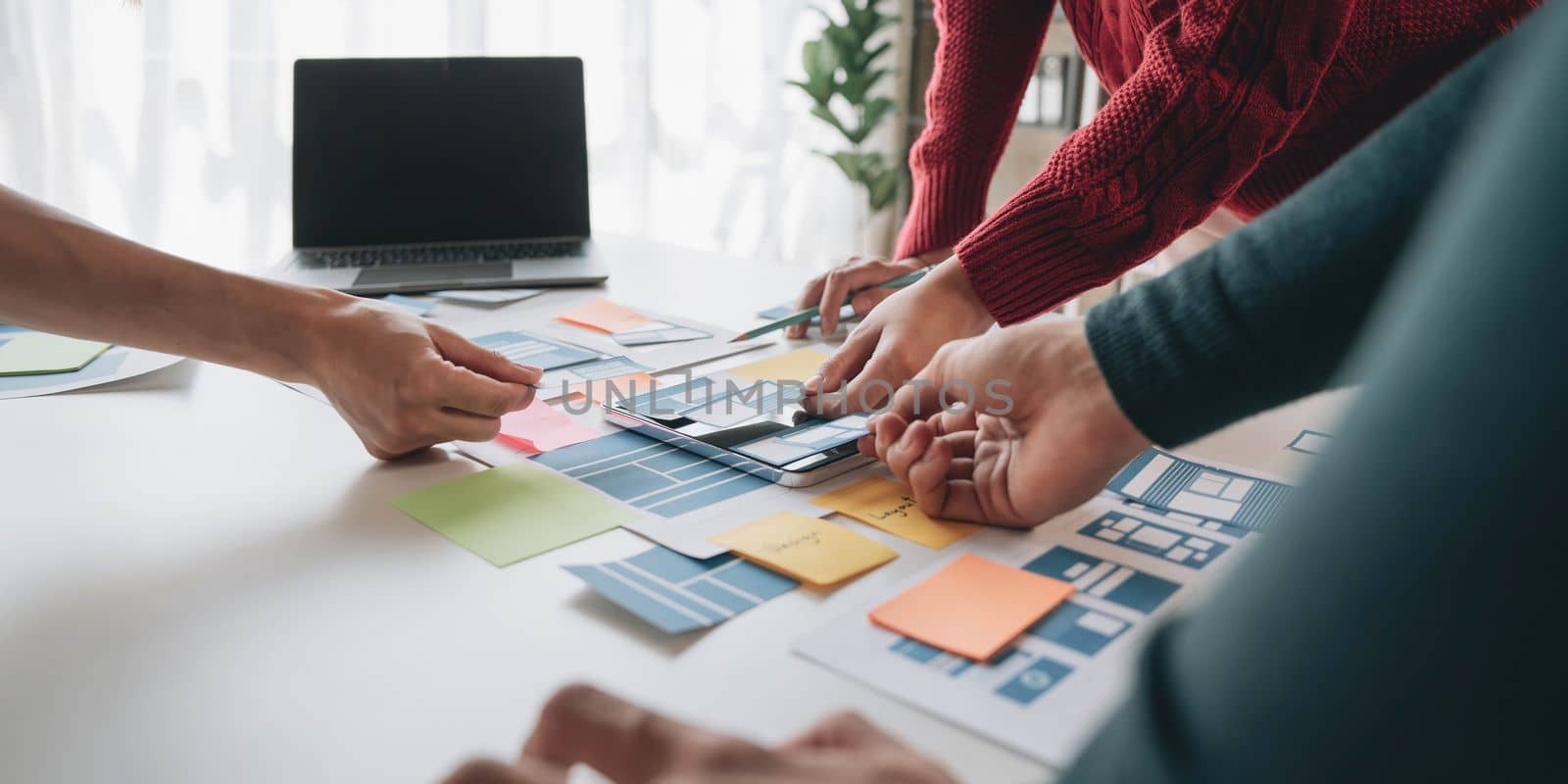 ux developer and ui designer brainstorming about mobile app interface wireframe design on table with customer breif and color code at modern office