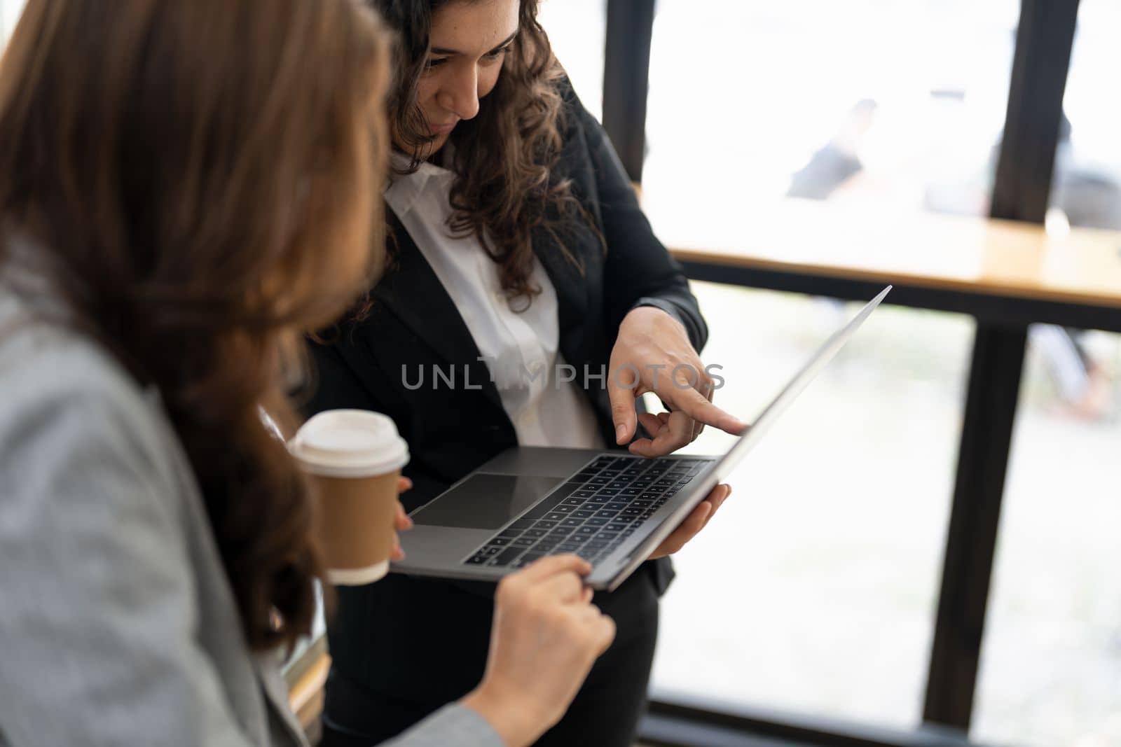 Diverse businesspeople cooperate work together discussing company financial statistics, multiracial colleagues collaborate brainstorm with finance on tablet