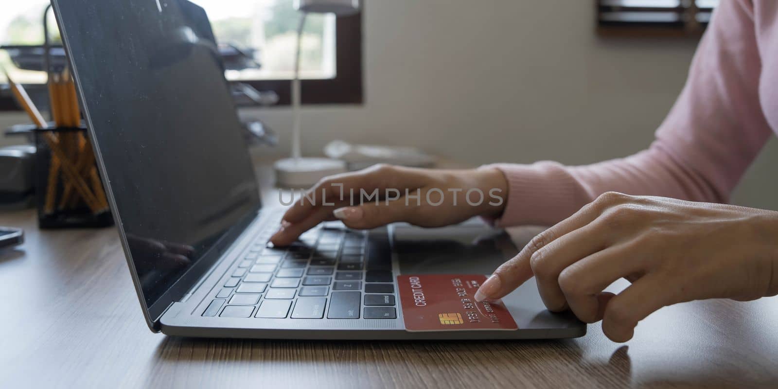 Close-up hand woman using smart phone, tablet payments and holding credit card online shopping, omni channel, digital tablet docking keyboard computer at home.