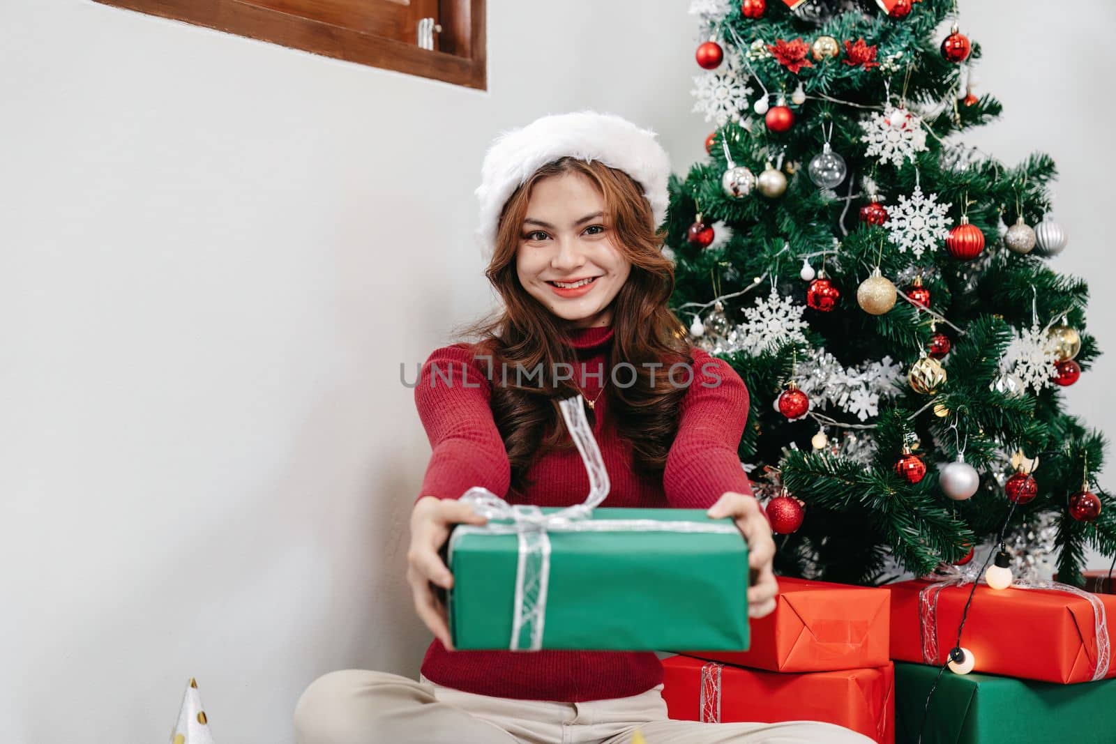 Portrait of a happy pretty young woman's hands hold christmas or new year decorated gift box.