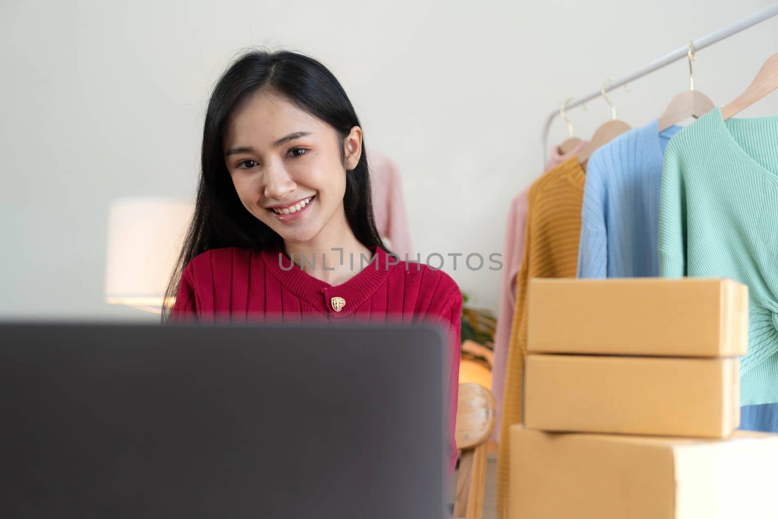 Portrait of Starting small businesses SME owners, Asian woman check online orders Selling products working with boxs freelance work at home office, sme business online small medium enterprise..