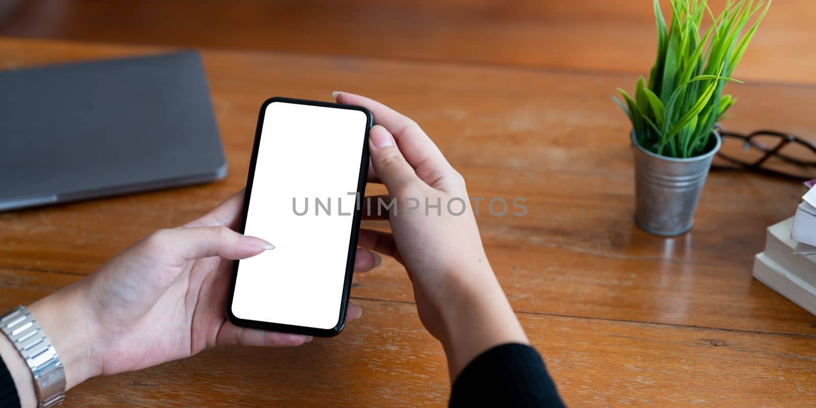 Top view Woman sitting and holding blank screen mock up mobile phone.