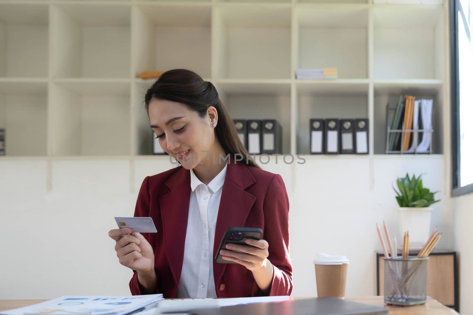 Happy asian Business woman pay online using mobile phone at the office