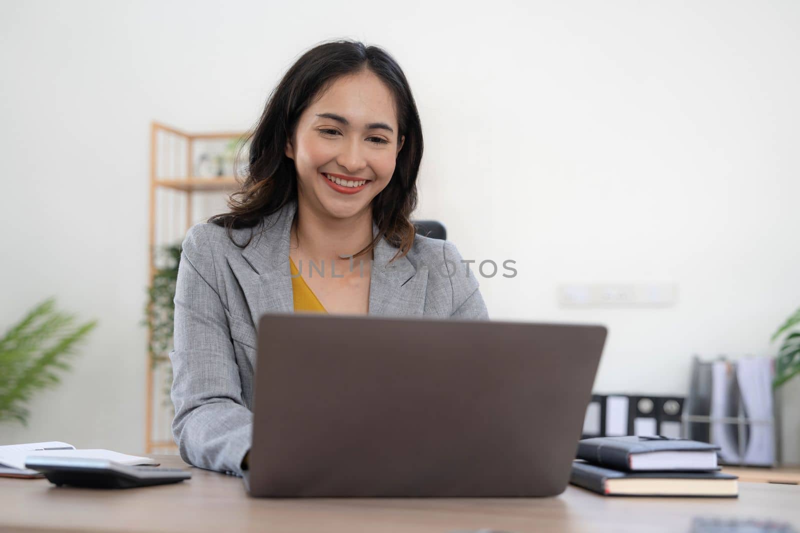 Portrait of an Asian young business Female working on a laptop computer in her workstation.Business people employee freelance online report marketing concept