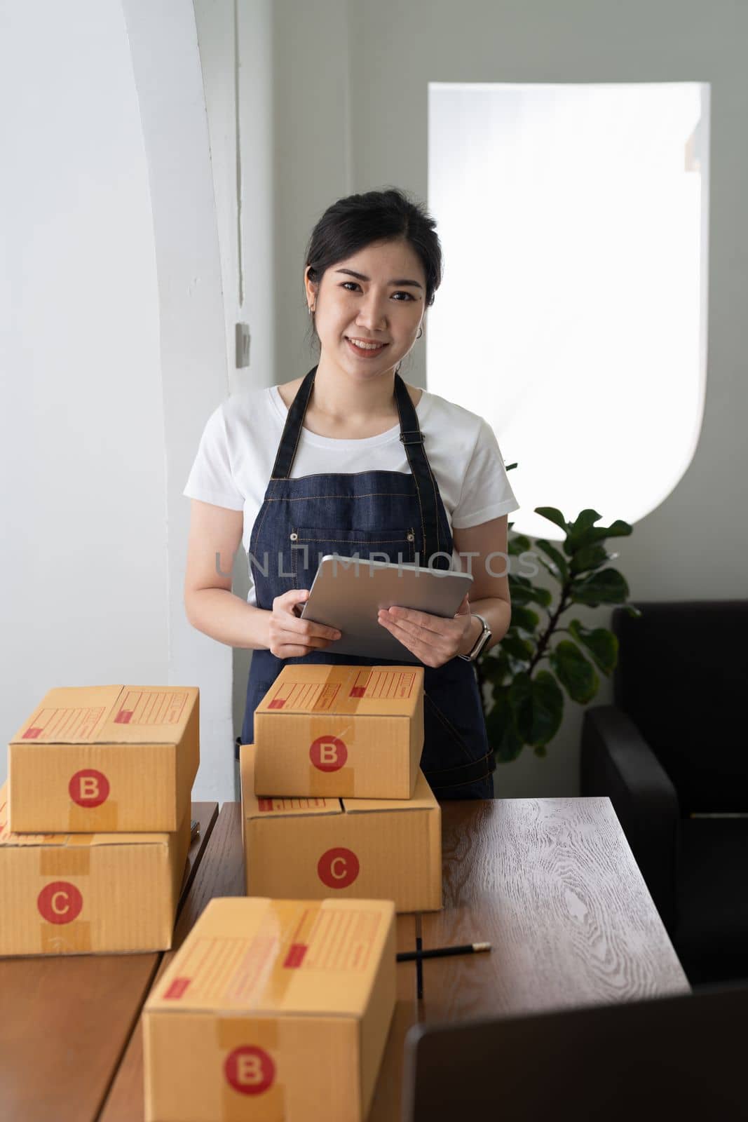 Portrait young asian small business owner at home, online marketing packaging and delivery scene, startup SME entrepreneur or freelance working at home concept.