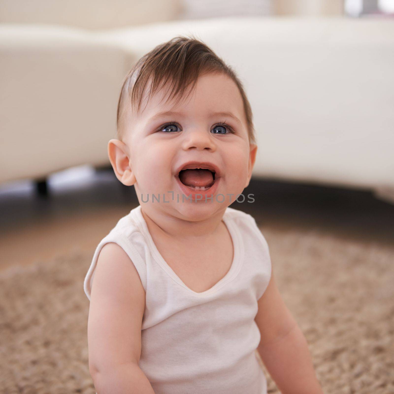 Delightfully adorable. a baby boy sitting on the carpet at home. by YuriArcurs