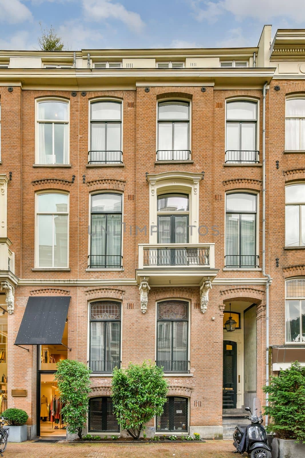 a brick apartment building with a motorbike parked outside by casamedia