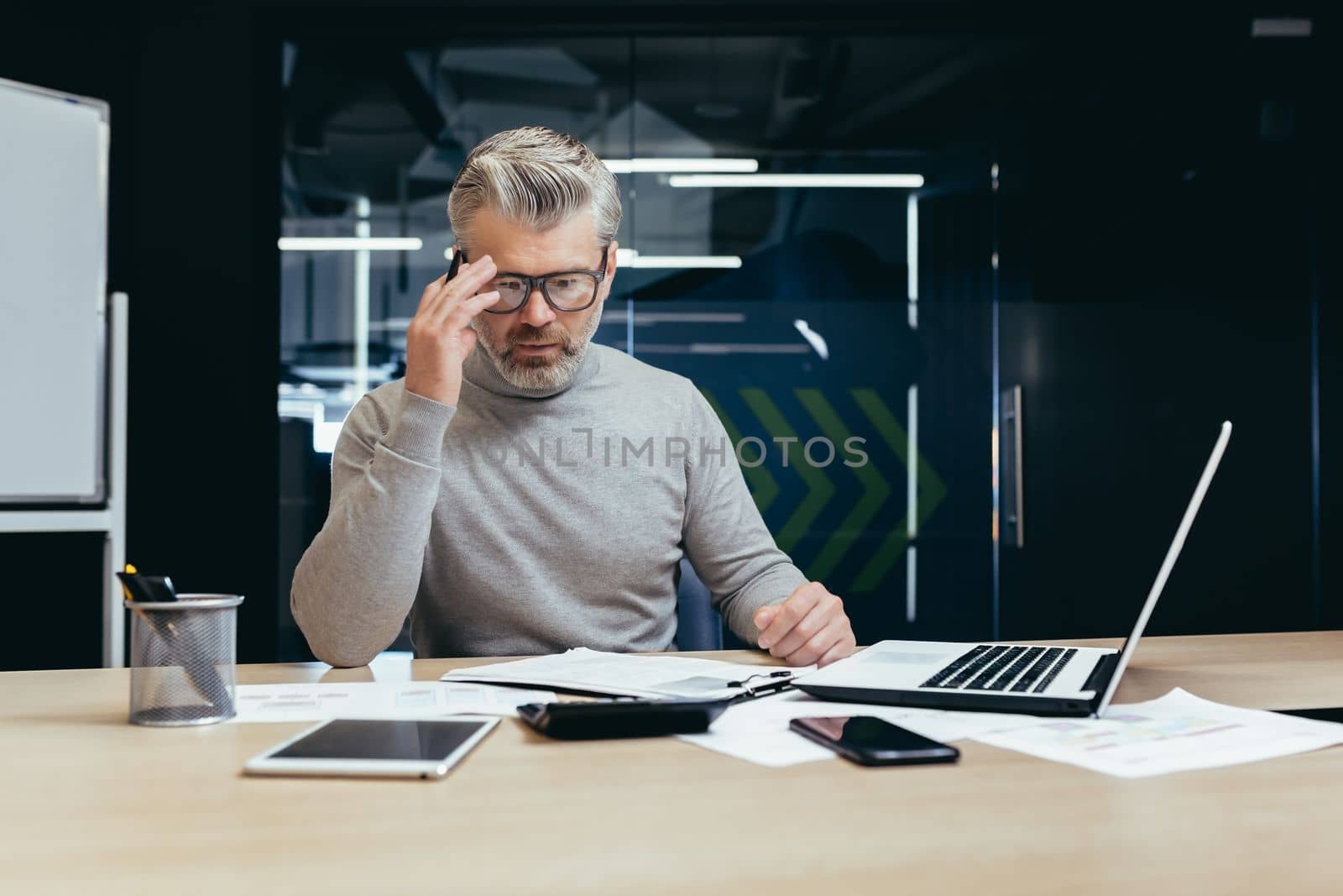 Senior thinking businessman working inside office with laptops, man thinking about important financial decision.