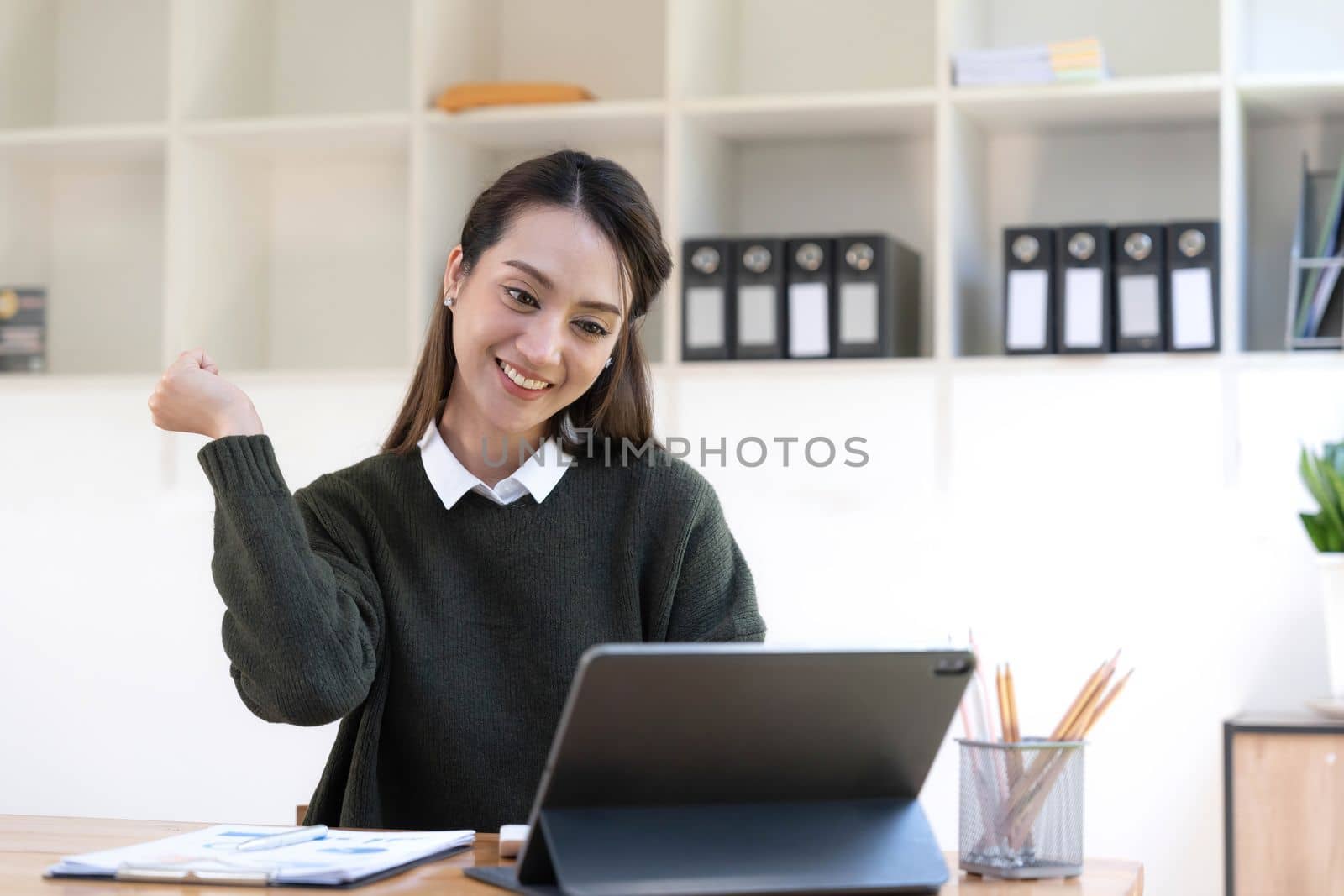 Pretty Asian businesswoman sitting on a laptop And the work came out successfully and the goal was achieved, happy and satisfied with her