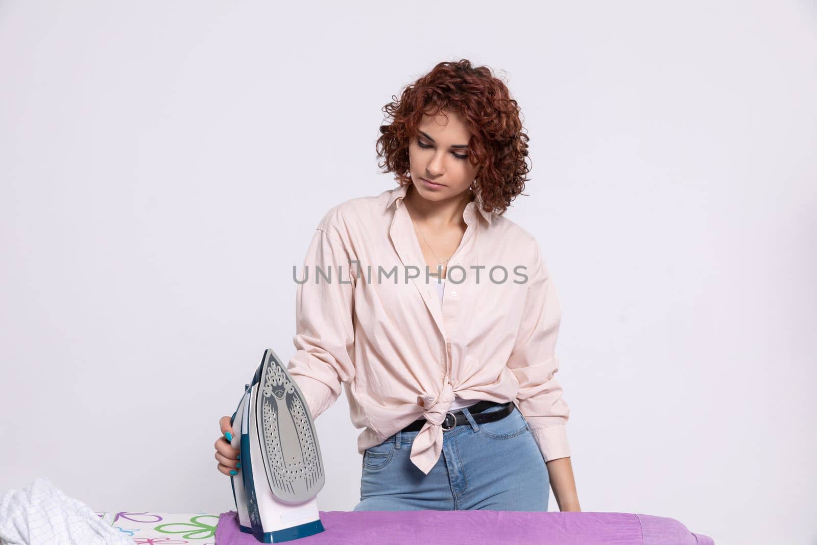 Woman fully prepared to take care of ironing men's shirts now. Daily household chores. Ironing board and iron.