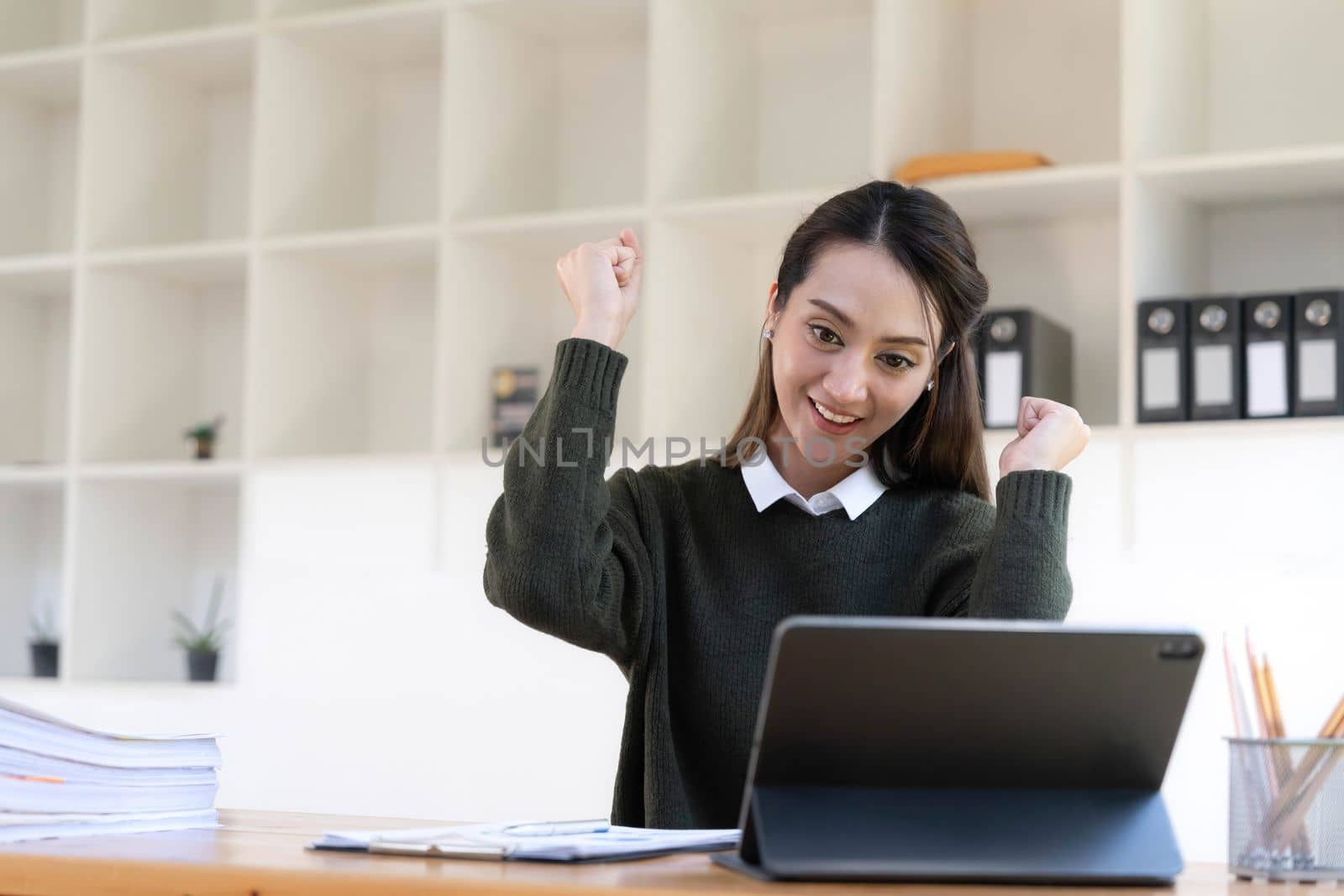 Pretty Asian businesswoman sitting on a laptop And the work came out successfully and the goal was achieved, happy and satisfied with her