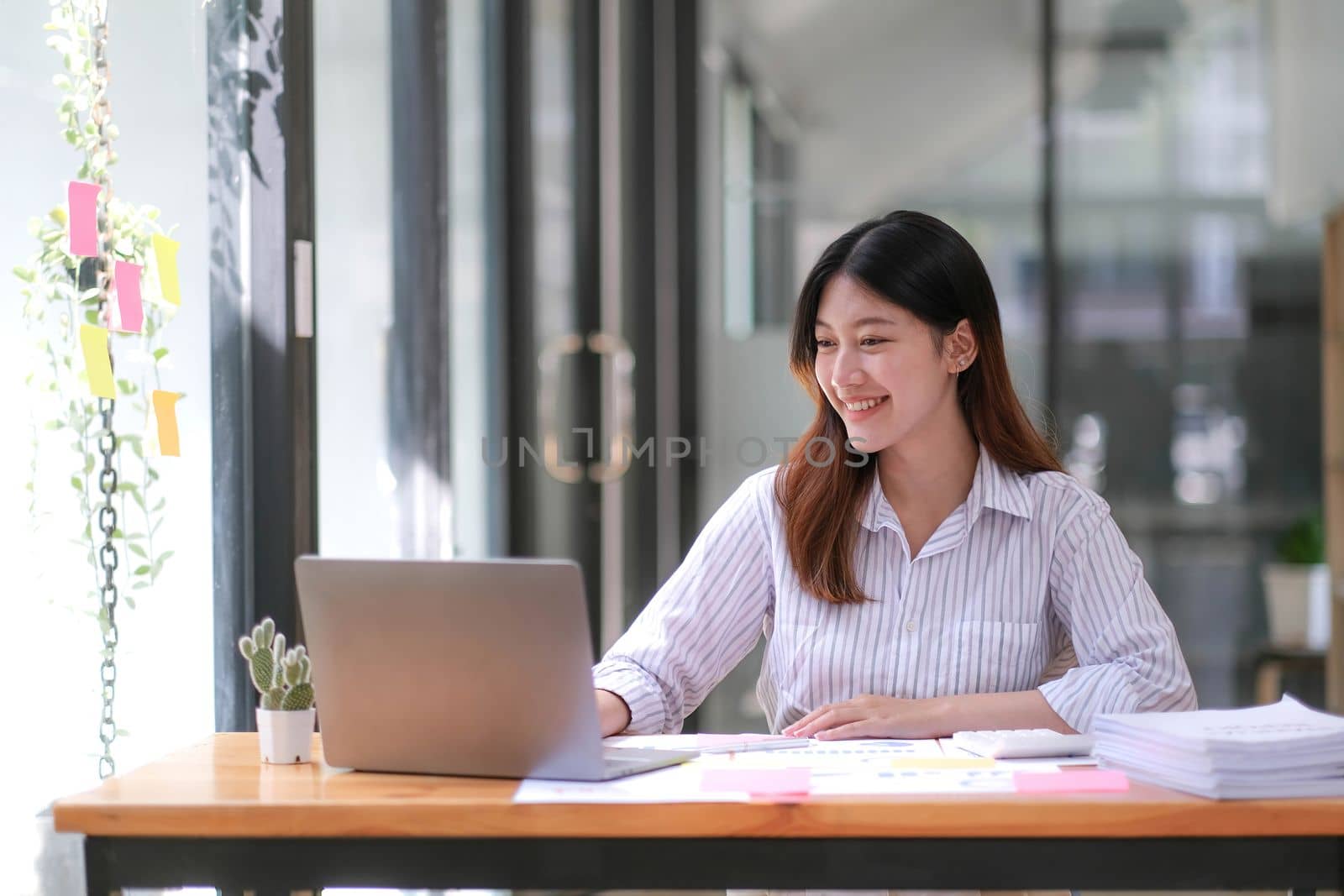 Young Asian businesswoman is happy to work at the modern office using a tablet..