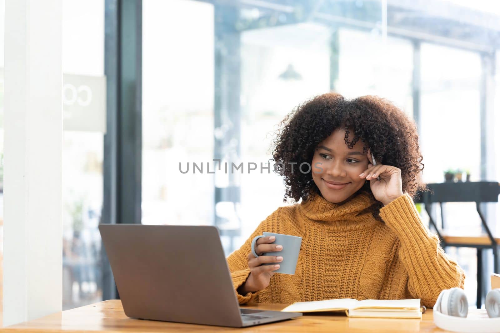 Photo of cheerful joyful woman in yellow shirt smiling work on laptop talk speak video call online. Smart ethnic female in earphones study distant on computer at home. Education concept...