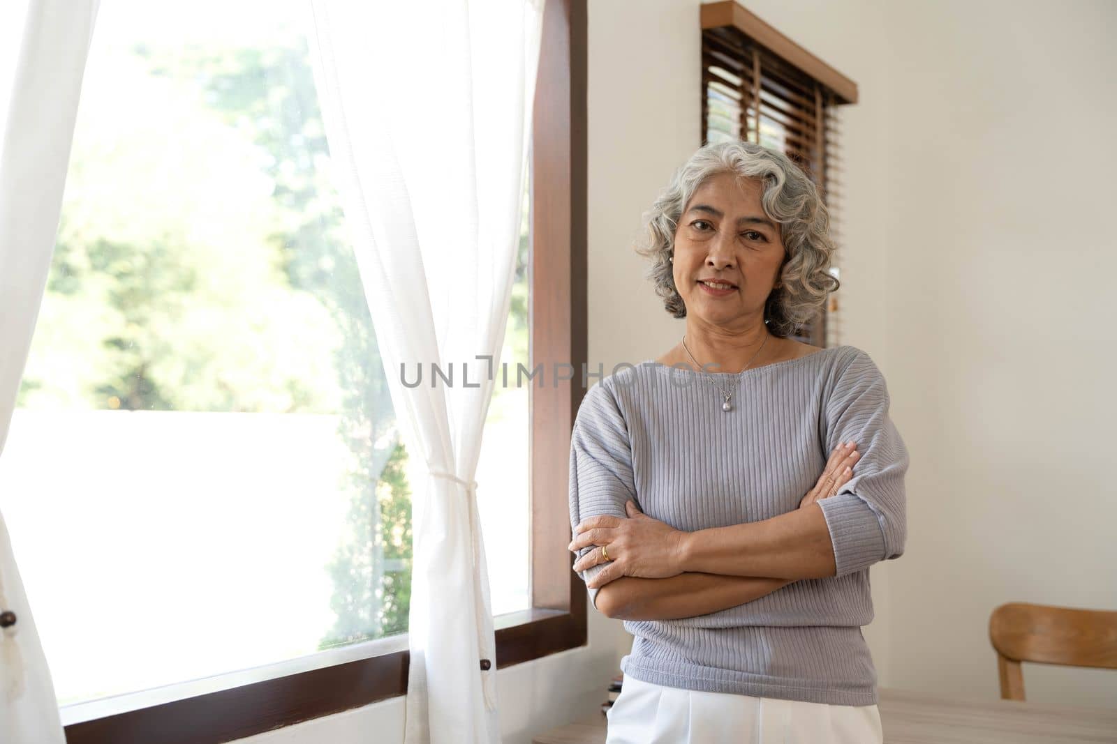 Portrait of smiling senior woman standing posing in home happy confident middle-aged female look at camera show confidence and success..
