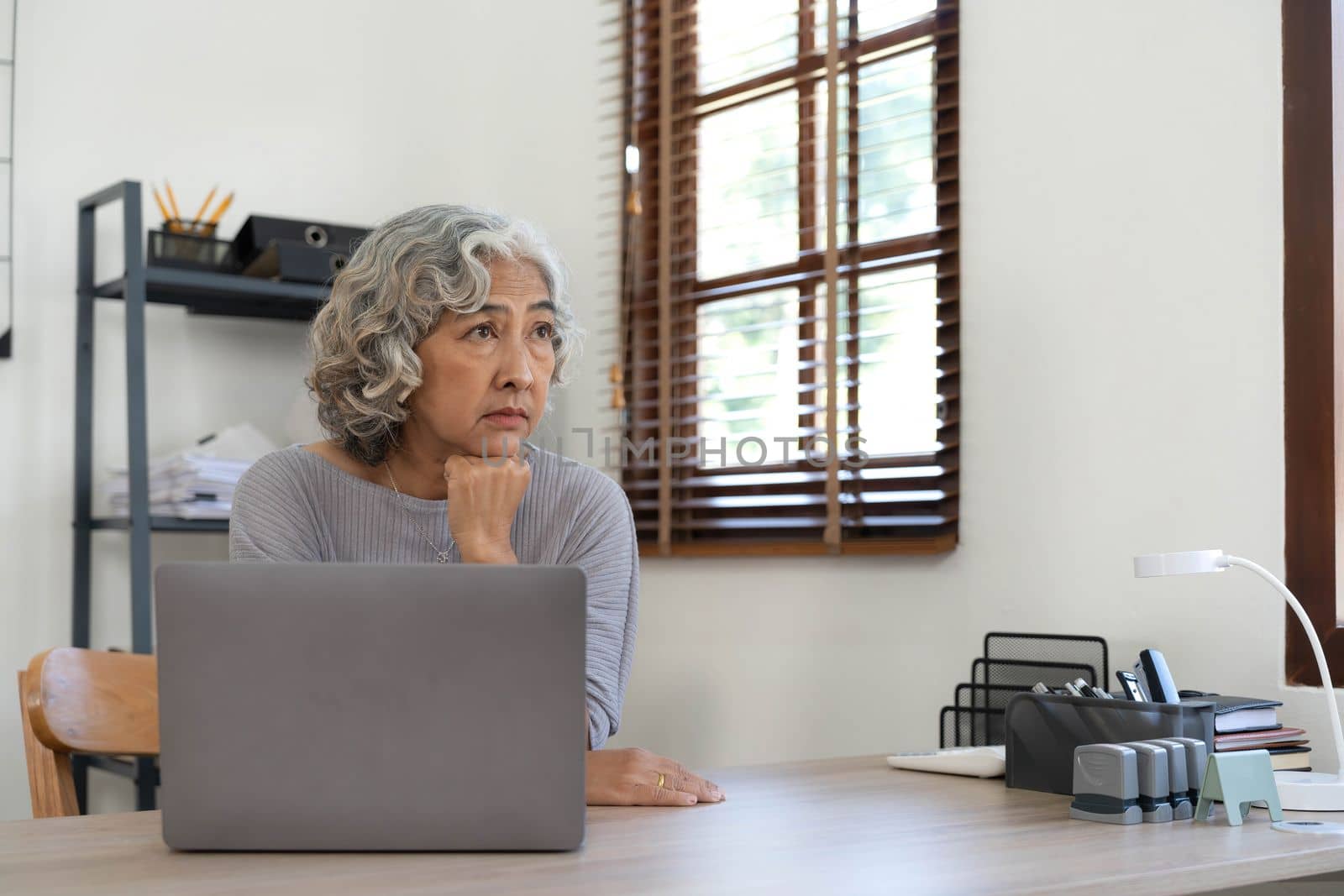 The elderly Asian woman sat in the home. she has stress and is sick. Retirement concept, senior health insurance.