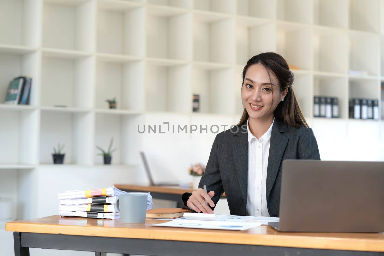 Portrait of Young woman using laptop computer at the office, Student girl working at home. Work or study from home, Asian woman freelance, business, lifestyle concept.