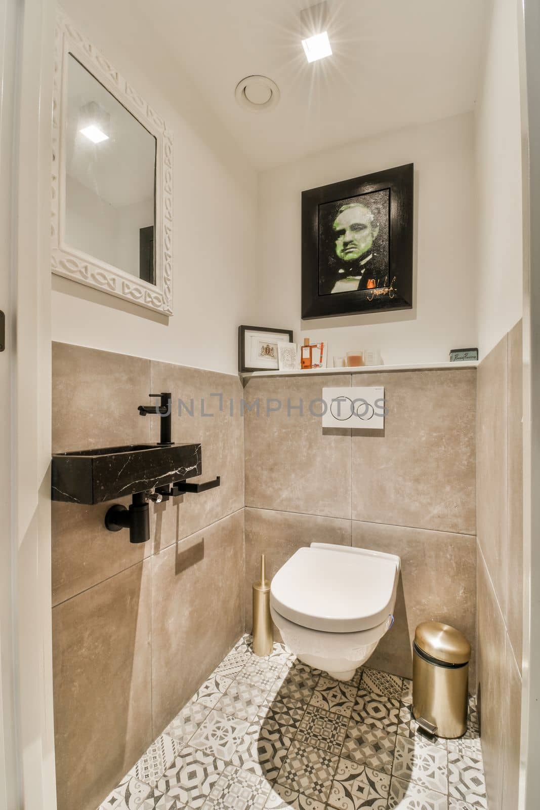 a bathroom with a toilet and mirror on the wall next to it is an image of a man's face